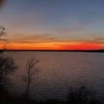 Sunset over calm lake water