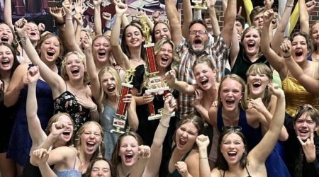 Celebration with trophies and raised fists.